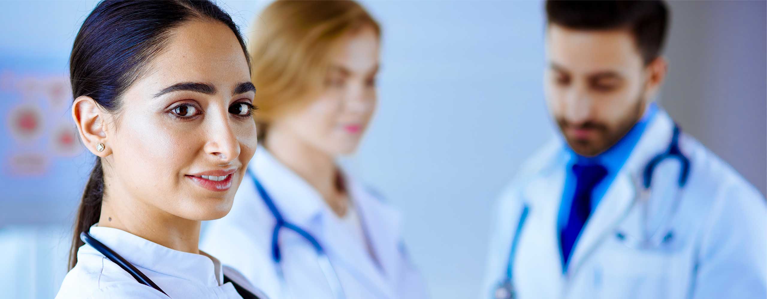 Confident female healthcare professional standing in front of medical colleagues, promoting career opportunities in home health care